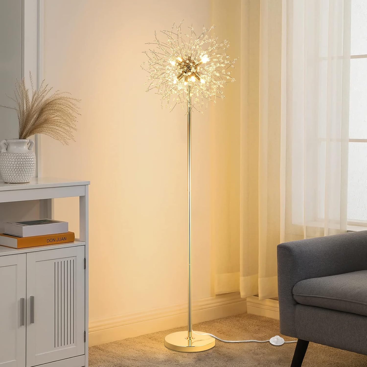 Decorative floor lamp in a living room setting with a gray sofa and white cabinet.