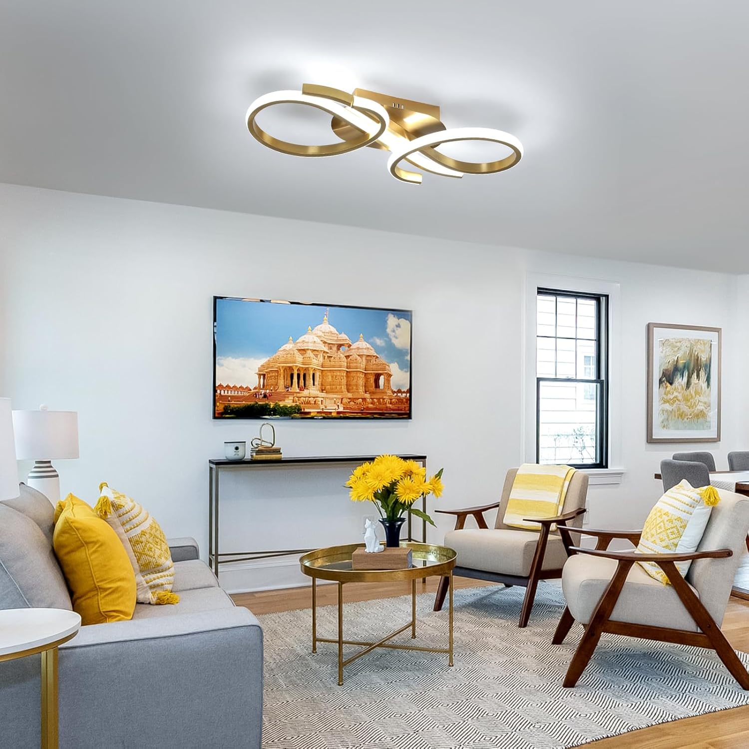 Modern living room with gold ceiling light fixture, gray sofa, and yellow accent pillows.