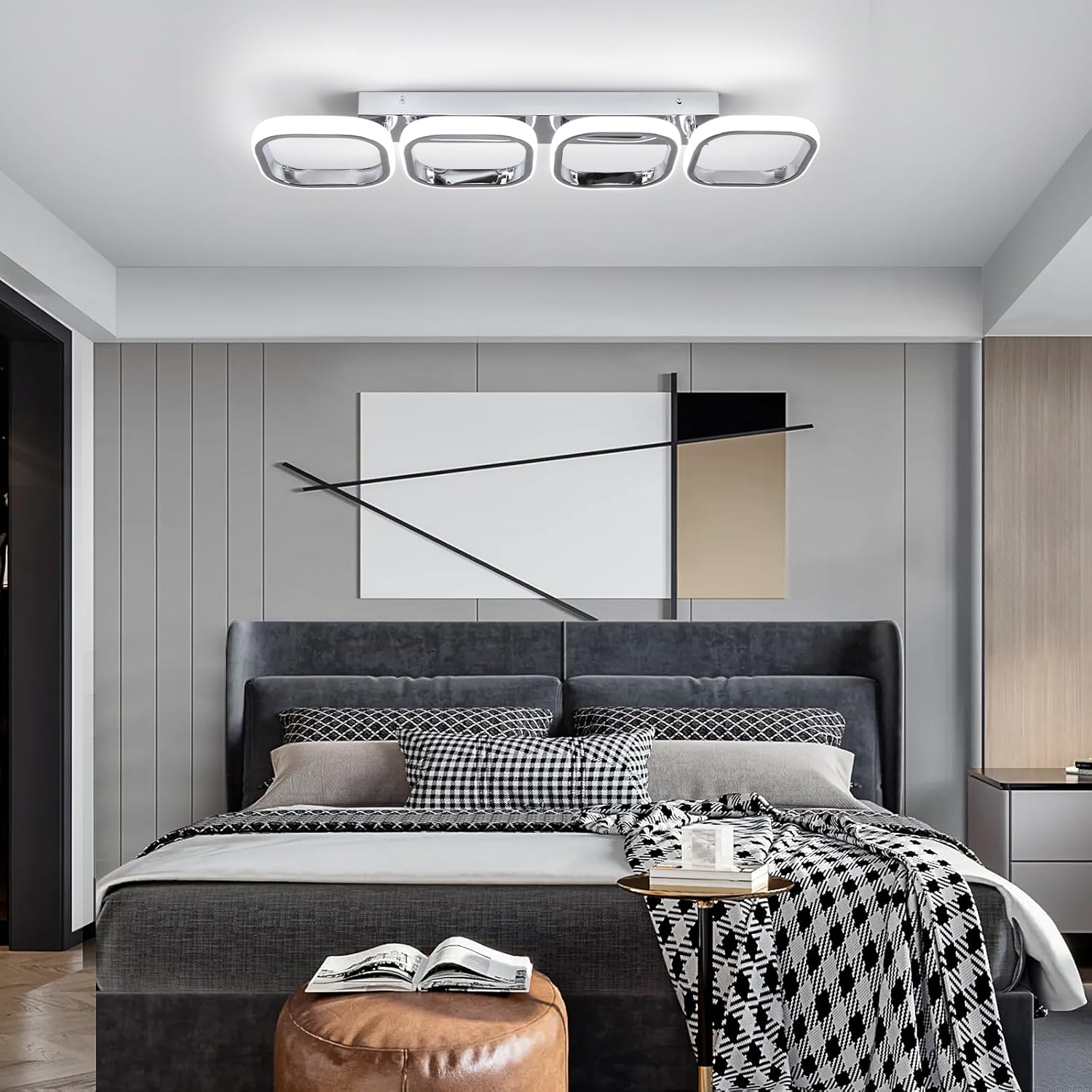 Modern bedroom with gray upholstered bed, abstract art on the wall, and a ceiling light fixture.