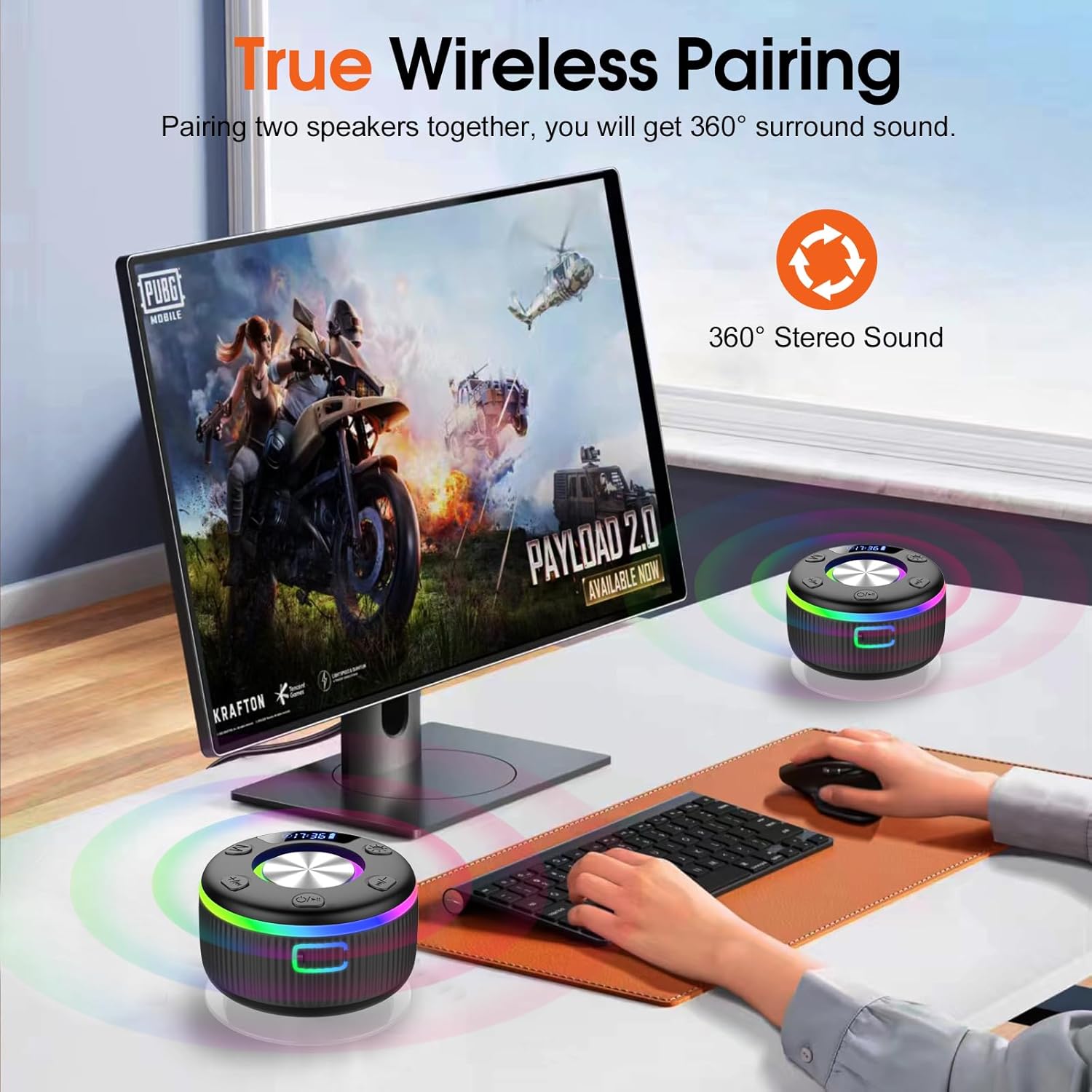 Gaming setup with two wireless speakers and a monitor displaying a game, emphasizing true wireless pairing and 360° surround sound.