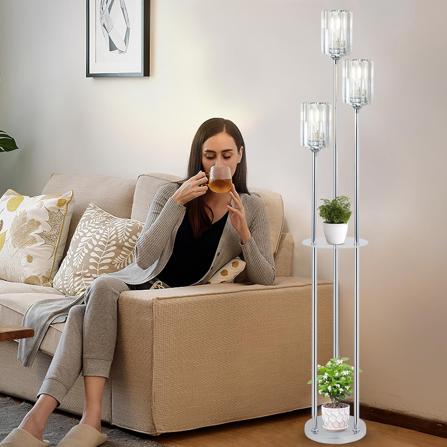 Woman sitting on a couch holding a glass of tea with a modern floor lamp in the background.