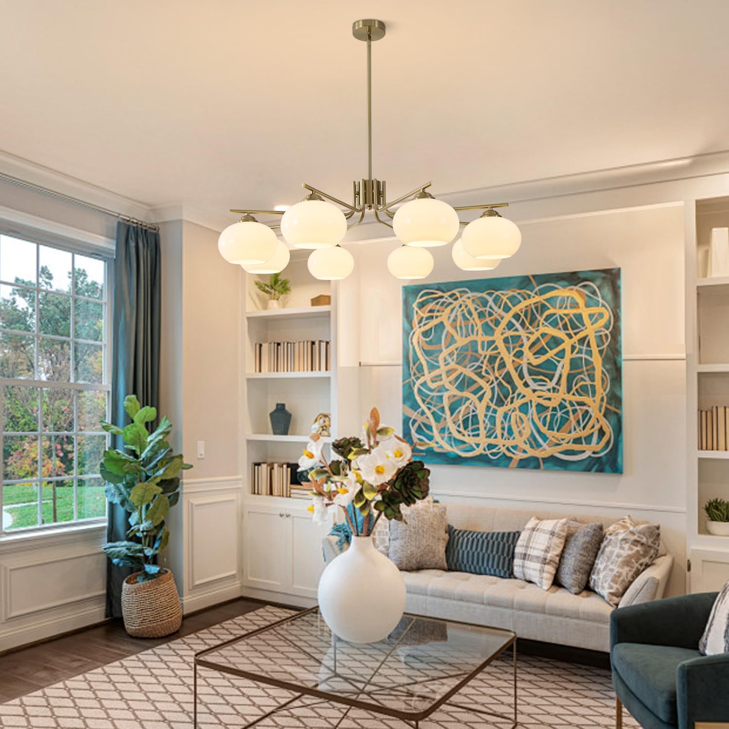 Modern living room with a chandelier, bookshelves, and abstract artwork.