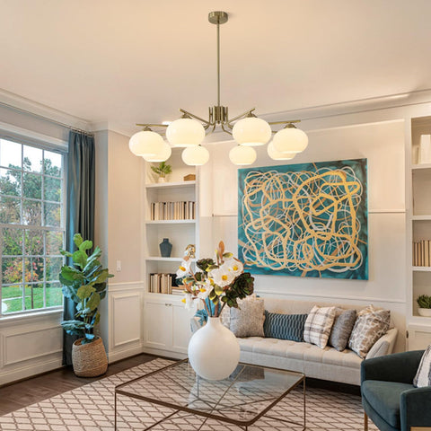 Modern living room with a chandelier, bookshelves, and abstract artwork.