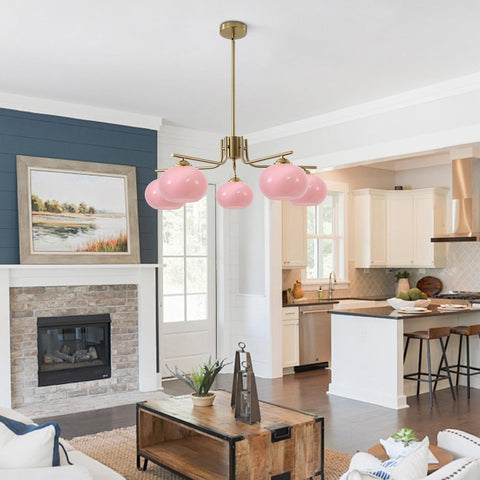 Modern living room with pink pendant light, fireplace, and kitchen in the background.