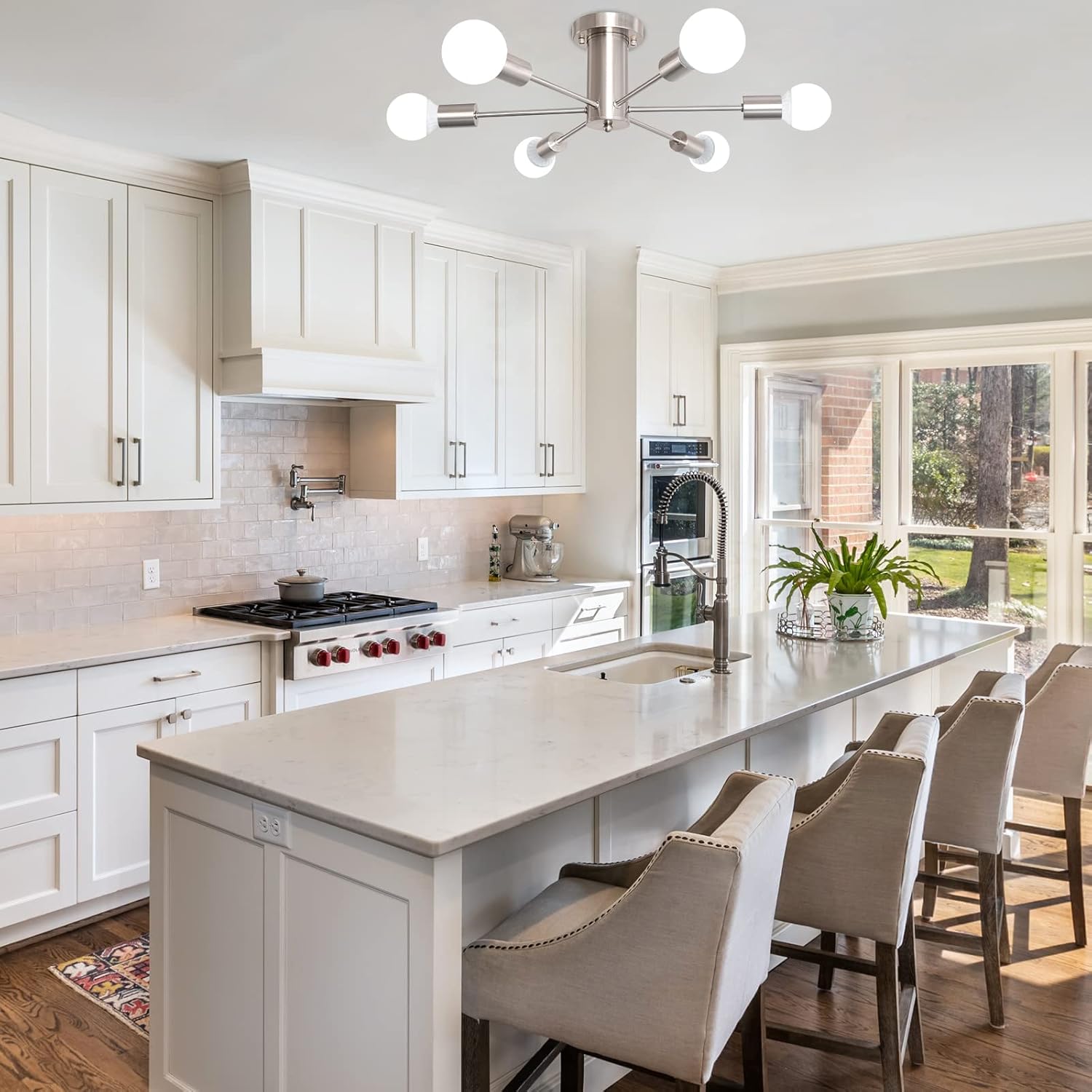 Modern kitchen with white cabinets, marble island, and stainless steel appliances.