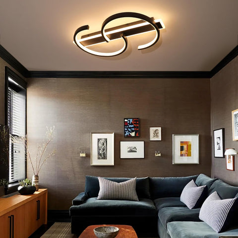Modern living room with a ceiling light fixture, dark gray sectional sofa, and wall art.