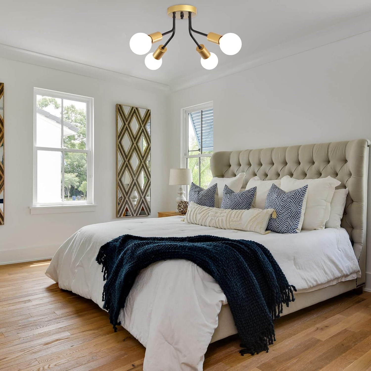Modern bedroom with a bed, decorative pillows, and a ceiling light fixture.