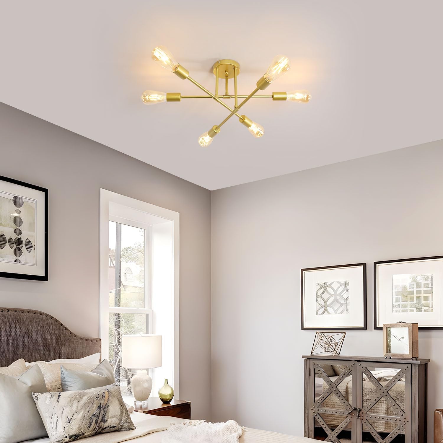 Modern gold ceiling light fixture in a bedroom setting with decor elements.