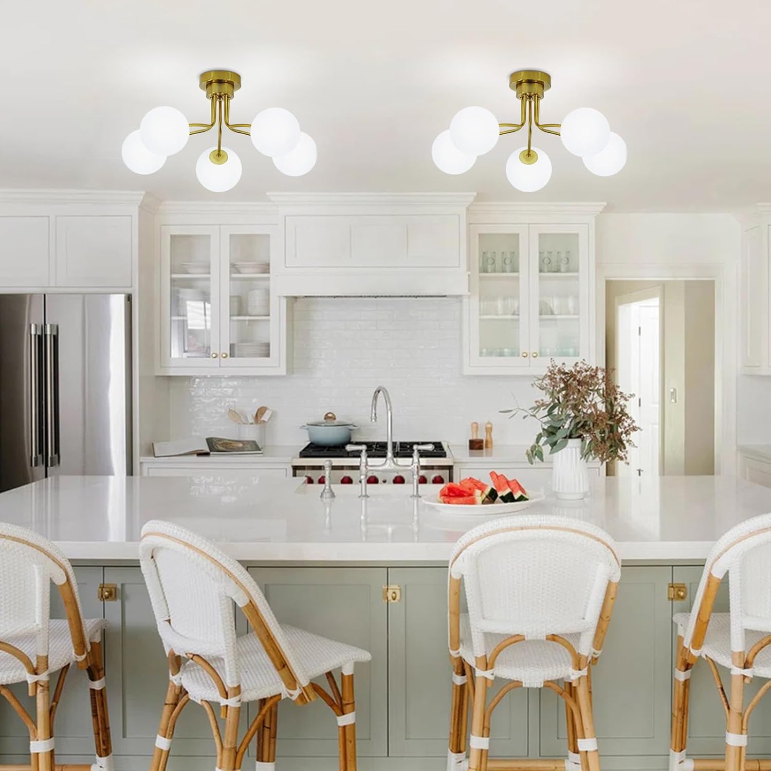 Modern kitchen with white cabinets, marble countertops, and decorative elements.