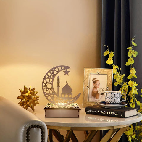 Decorative setup with a lamp, photo frame, books, and flowers on a table.