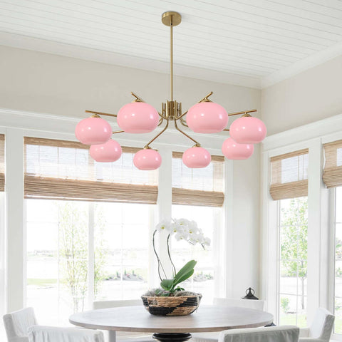 Pink chandelier in a room with large windows and a table with a plant.