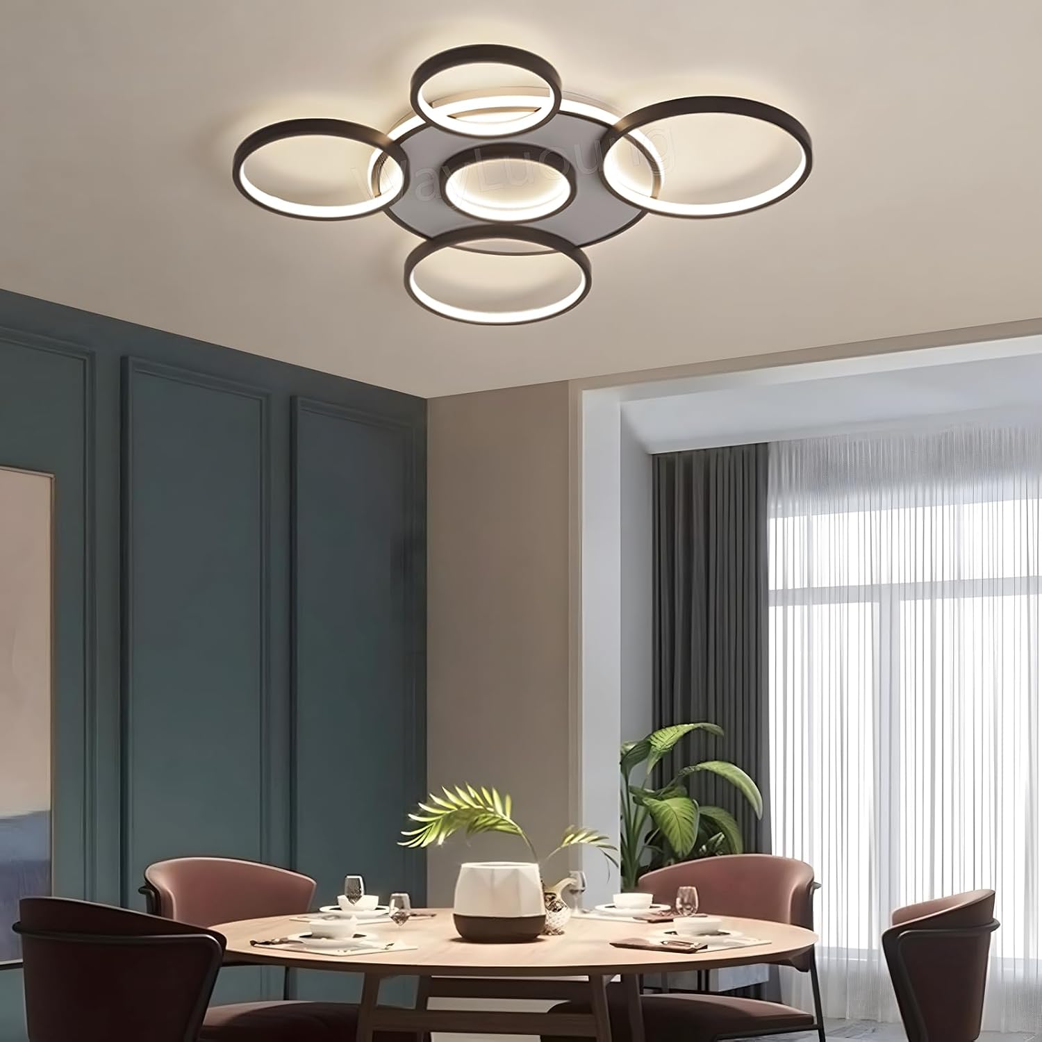 Modern ceiling light fixture in a dining room setting with a round table and chairs.