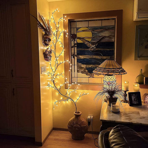 Decorative setup with fairy lights, vases, and a lamp in a room.