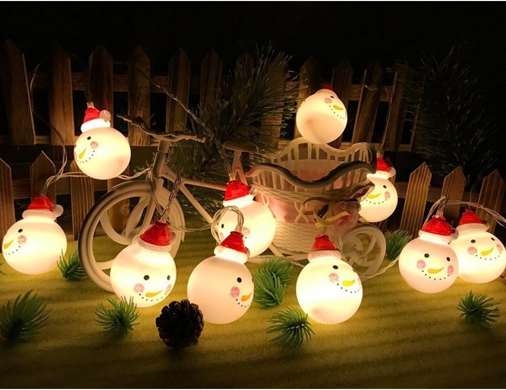 String lights with snowman design on a wooden surface with a bicycle in the background.
