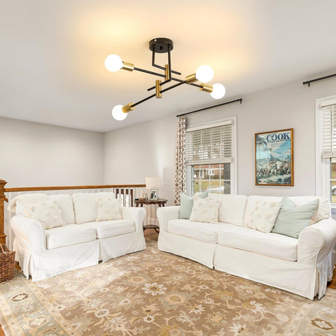 Living room with white sofas, a decorative rug, and a modern chandelier.