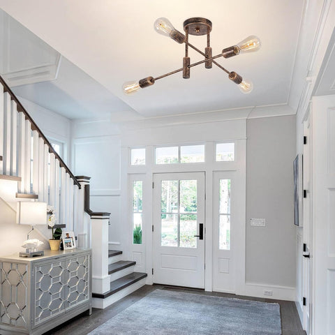 Foyer with staircase, modern light fixture, and large windows.