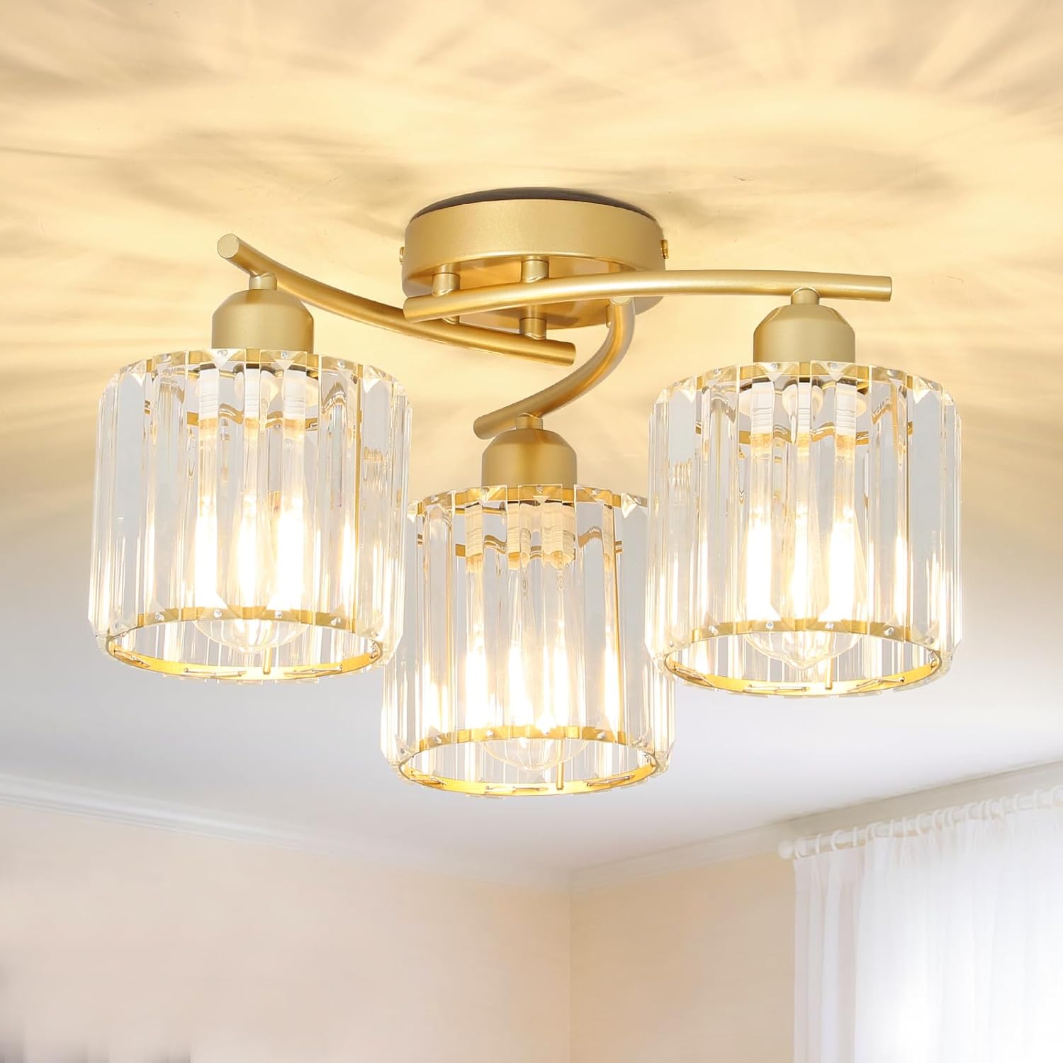 Ceiling light fixture with gold finish and clear glass shades in a room setting.