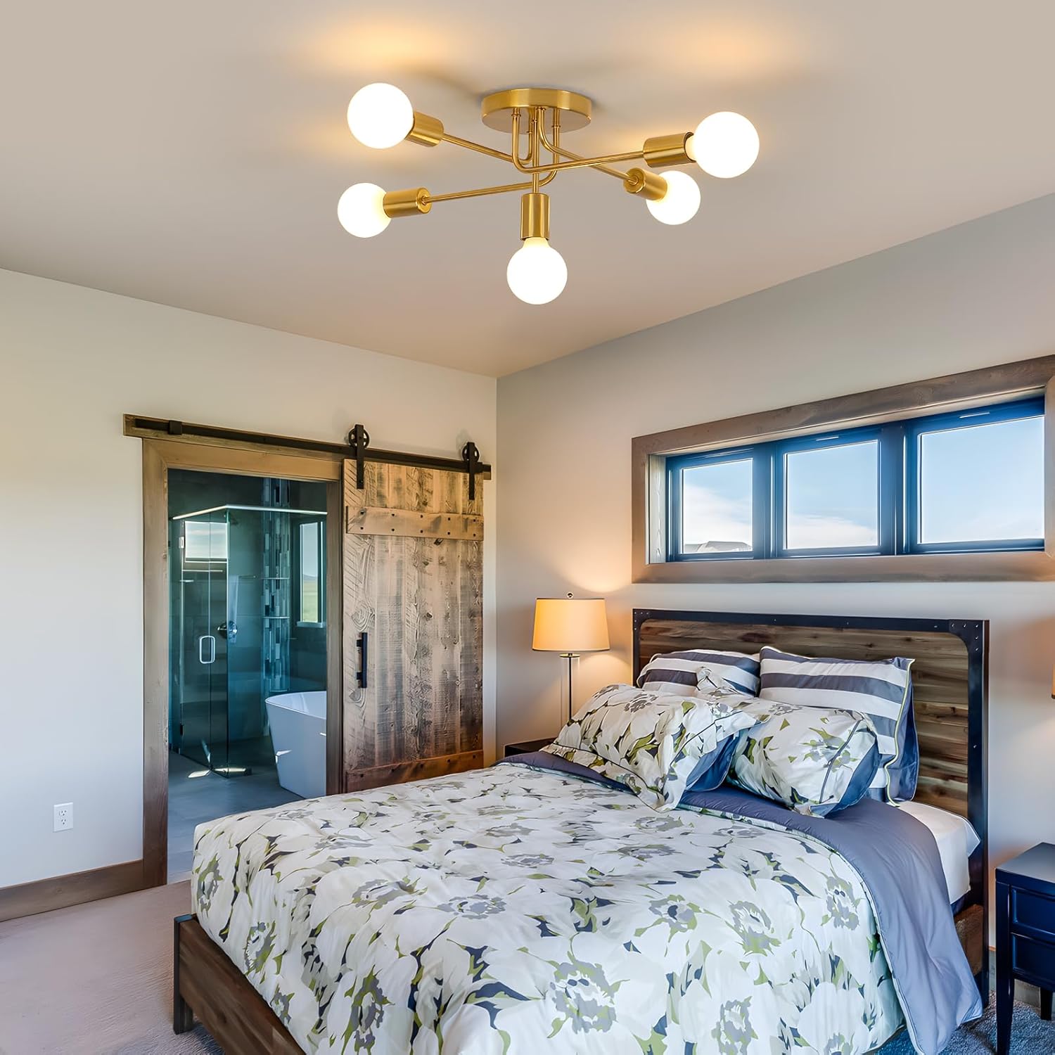 Modern bedroom with a bed, sliding barn door, and ceiling light fixture.