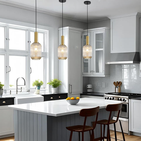 Modern kitchen with white island, wooden chairs, and pendant lights.