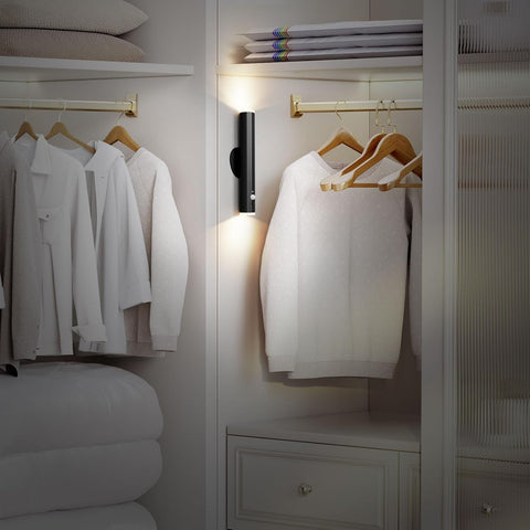 Closet with white shirts on hangers and a mirror reflecting the room.