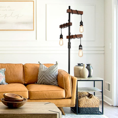Living room with a brown leather sofa, decorative pillows, and a floor lamp.