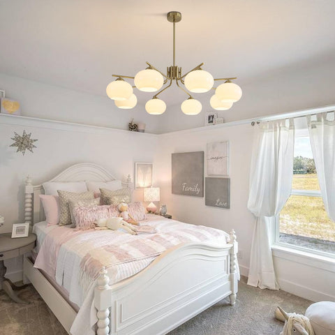 Neatly decorated bedroom with a white bed, lamp, and decor elements.