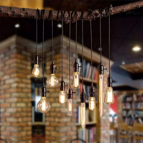 Vintage light bulbs hanging from a wooden beam with a blurred bookshelf background