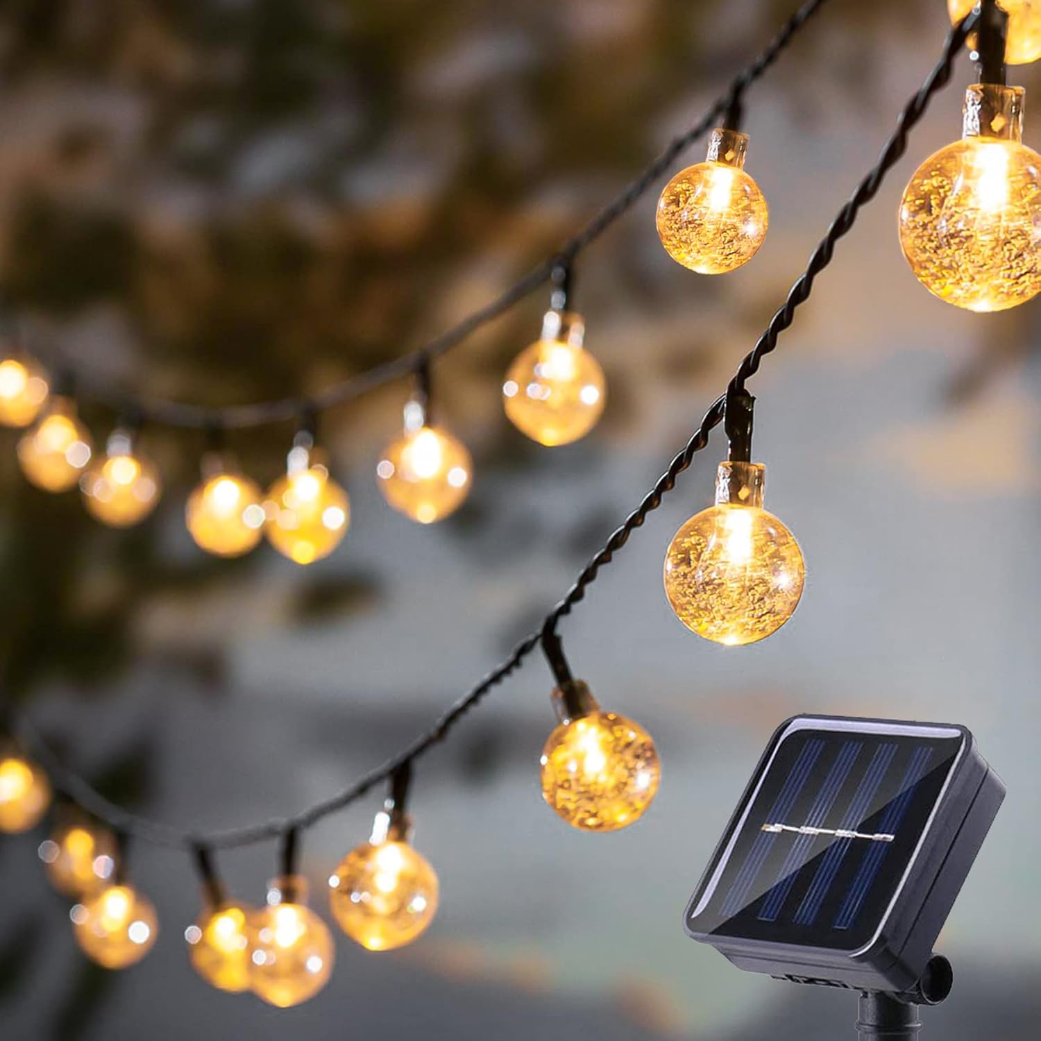 String of decorative lights with a solar panel power source, hanging outdoors.
