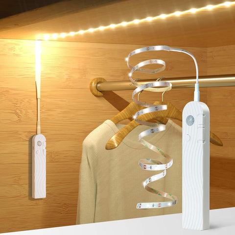 Clothing hanger with LED strip light and remote control on a wooden background