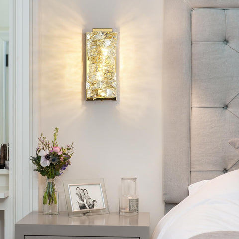 Decorative wall sconce in a bedroom setting with flowers and a photo frame on a nightstand.
