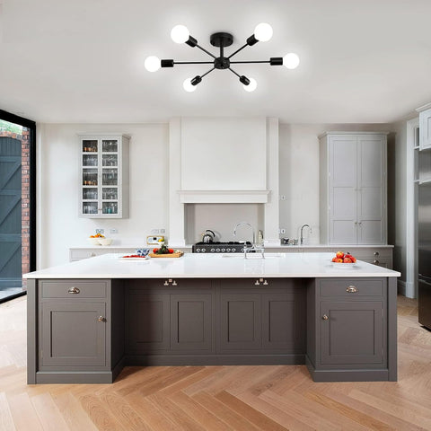 Modern kitchen with gray island, white countertops, and stainless steel appliances.