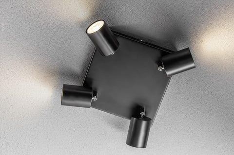 Modern ceiling light fixture with four cylindrical lights on a gray ceiling.