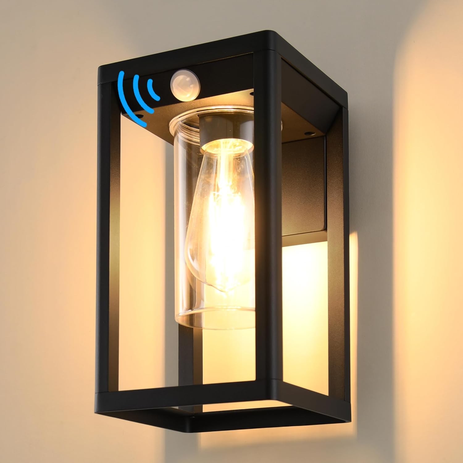 Black outdoor wall light fixture with glass cover and motion sensor on a neutral background