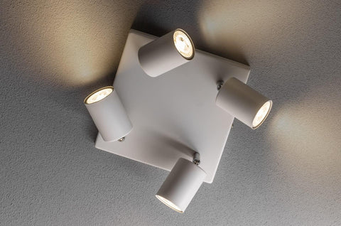Ceiling light fixture with four cylindrical lights on a gray ceiling