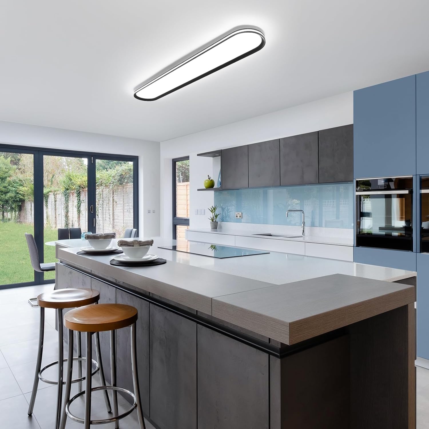 Modern kitchen with a island, stools, and large windows.