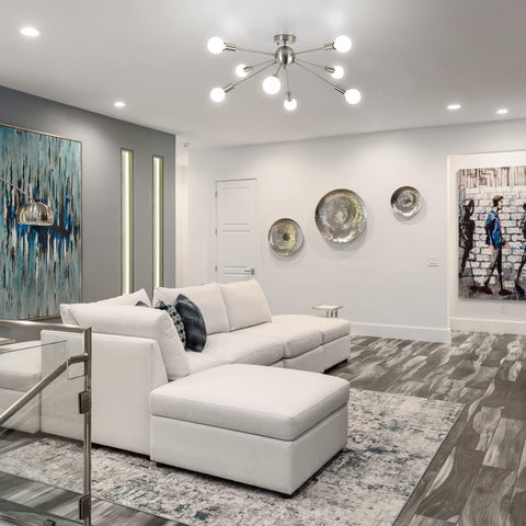 Modern living room with a white sectional sofa, abstract art, and decorative plates.
