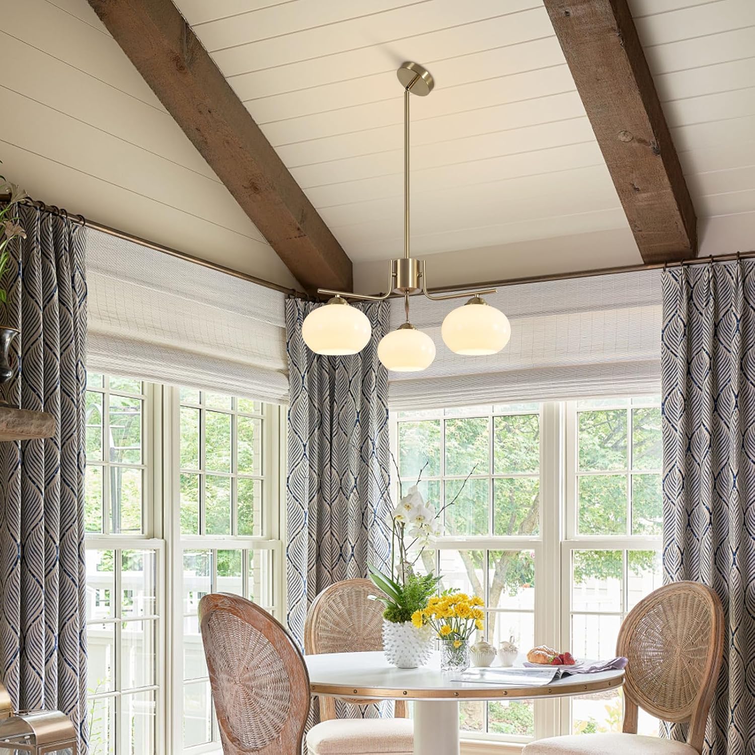 Dining room with wicker chairs, a table, and a pendant light fixture.