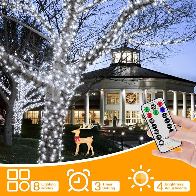 Decorative outdoor string lights with a remote control in front of a building.