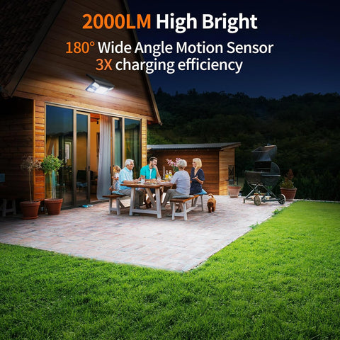 Family gathered around a table on a patio at night with outdoor lighting highlighting features.