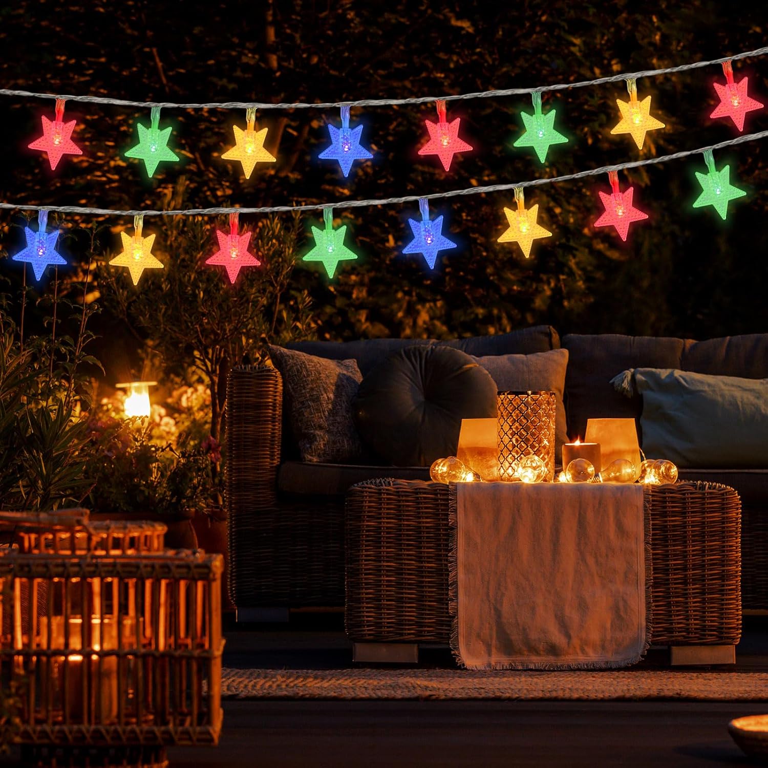 Colorful string lights above a outdoor seating area with a couch and small table.