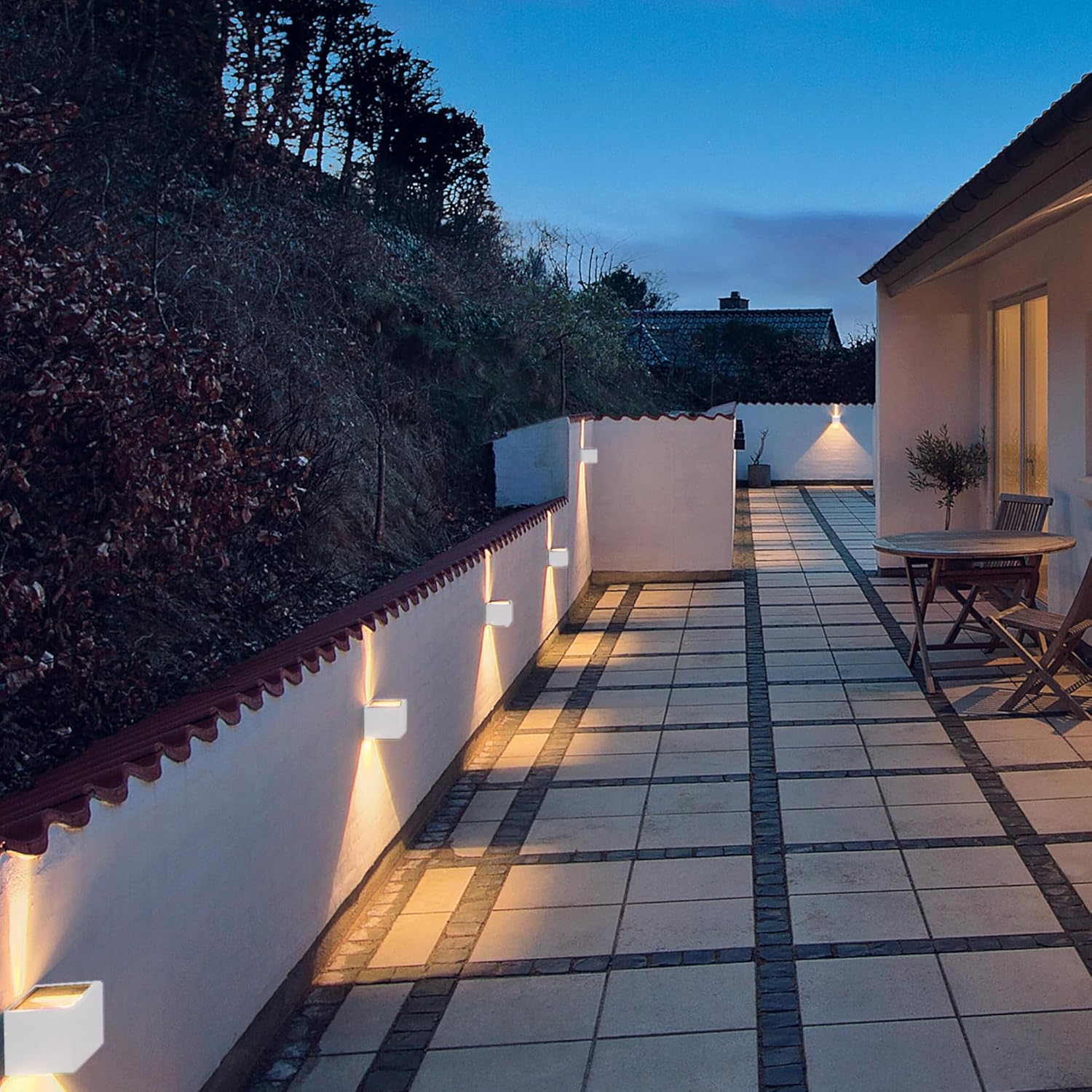 Evening view of a patio area with outdoor furniture and lighting.