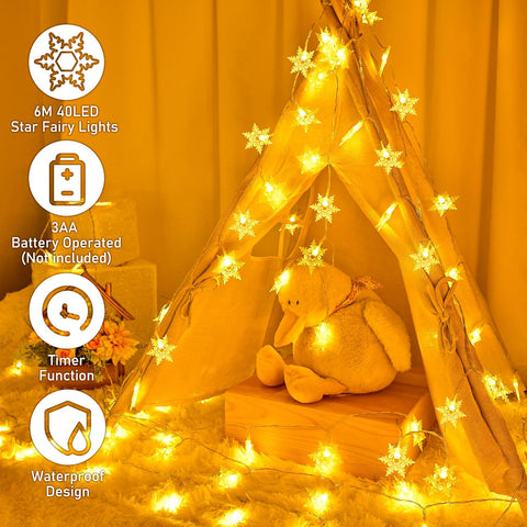 Star fairy lights with a teddy bear inside a wooden teepee against an orange curtain.