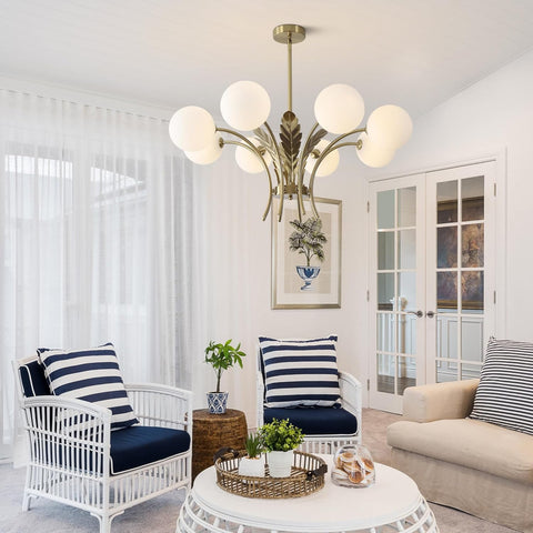 Living room with white wicker chairs, beige sofa, and a chandelier.