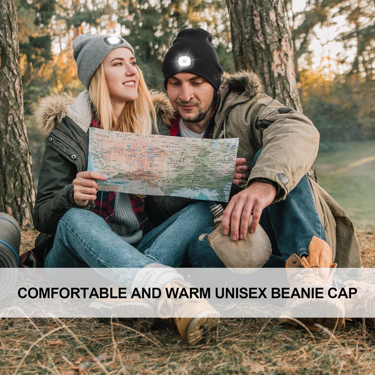 Two people sitting outdoors holding a map, wearing beanies.