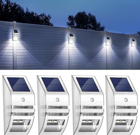 Pack of 4 LED solar security lights mounted on a fence at night

