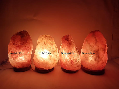 Four illuminated Himalayan salt lamps on a soft background with 'Needs & Gifts' branding.