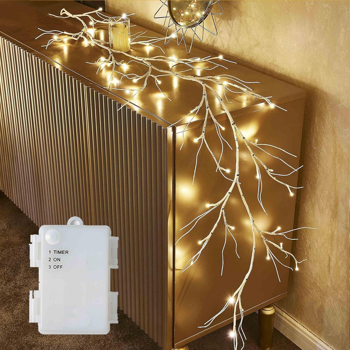 Decorative branch lights on a gold cabinet with a timer control.