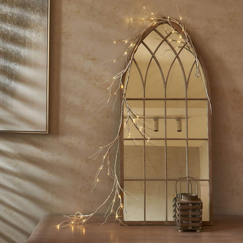 Decorative mirror with fairy lights on a textured wall