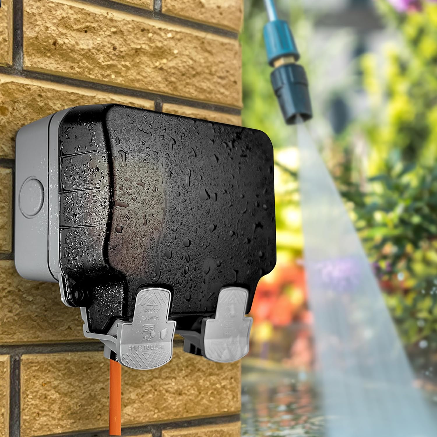 Black garden hose holder attached to a brick wall with water spraying in the background