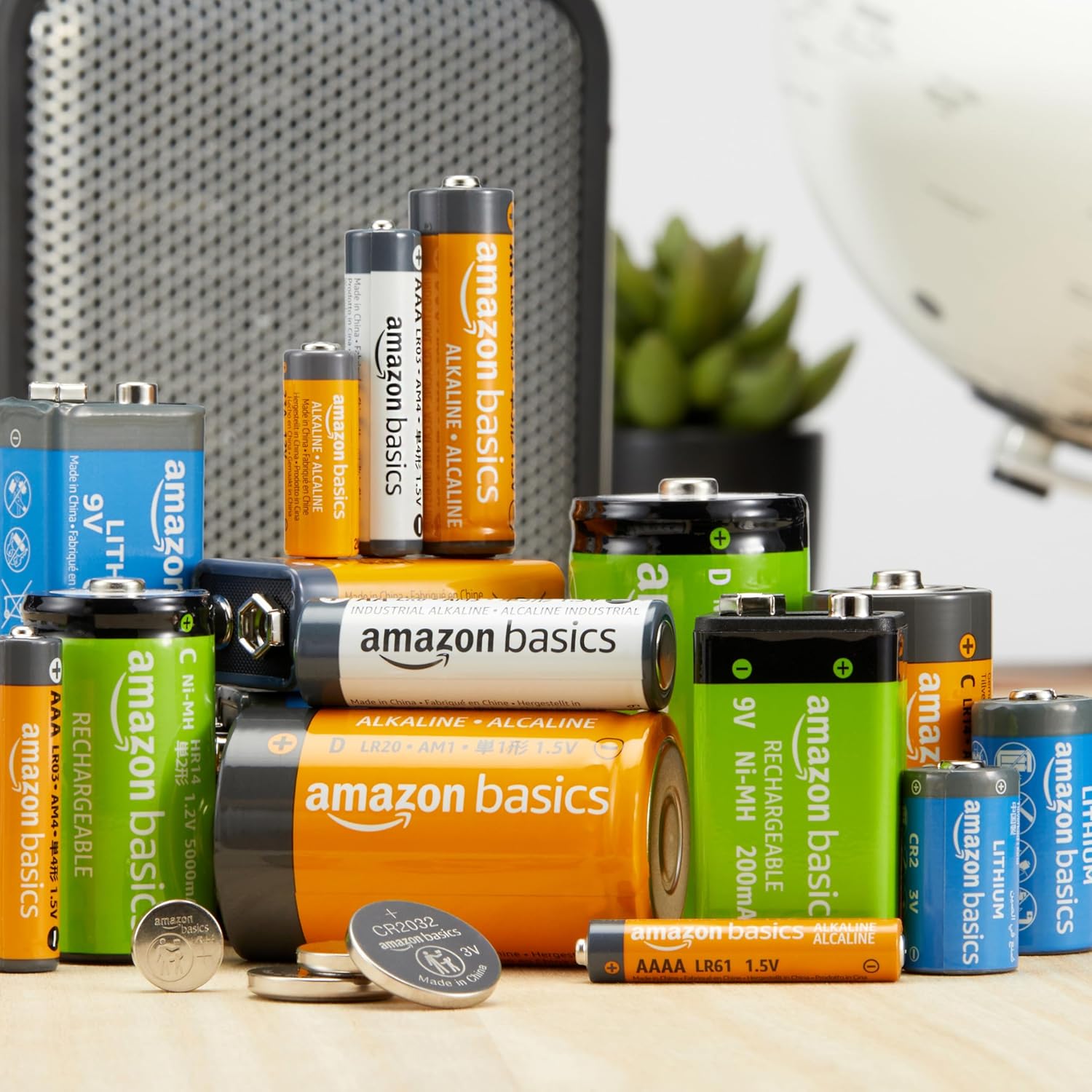 Assorted Amazon Basics batteries on a desk with a blurred office background